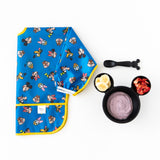 A Bumkins Sleeved Bib 2 Pack: Mickey & Friends Excellent Eight lays folded beside a bowl with yogurt & fruit and a spoon on a white background.