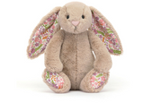 The Jellycat Blossom Bunny Petal Little has bashful beige fur, floral ears and feet, and sits upright.