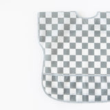 Bumkins Junior Bib: Charcoal Check, with easy-wipe waterproof fabric and a curved neckline, lays flat on a white background.