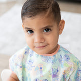 Close-up of a young boy wearing a Bumkins Junior Bib: Disney Aloha Stitch.