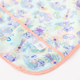 Close-up of Bumkins Junior Bib: Disney Aloha Stitch on a white background, with focus on the logo tag and front pocket.