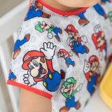 Close-up of a child's shoulder wearing a Bumkins Junior Bib: Super Mario™ & Luigi.