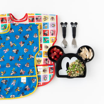 Two Bumkins Junior Bibs (Mickey & Friends) and a Mickey-shaped plate with strawberries, chicken & veggies.
