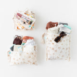 Bumkins The Chaos Coordinator Deluxe 5-Piece Set: Palm Daze is neatly arranged on white, holding clothes, makeup, sunglasses, and more.