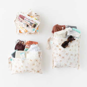 Bumkins The Chaos Coordinator Deluxe 5-Piece Set: Palm Daze is neatly arranged on white, holding clothes, makeup, sunglasses, and more.