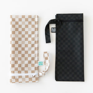 Bumkins Wet Bag 2 Pack in Sand & Black Check: two rectangular waterproof bags, laid flat on a white surface.