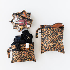 Roamio by Bumkins The Commuter Deluxe 5-Piece Set: Leopard holds travel essentials on a white background.