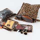 Roamio by Bumkins The Commuter Essential 4-Piece Set: Leopard holds shoes, makeup, and headphones on a white background.