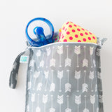 Bumkins Wet Bag: Arrow holds a yellow & pink polka dot swimsuit and a blue fan on a white background.