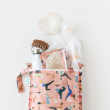 Bumkins Wet Bag: Yoga Pals holds a water bottle, breast pump parts, nursing pads & baby essentials on a white background.