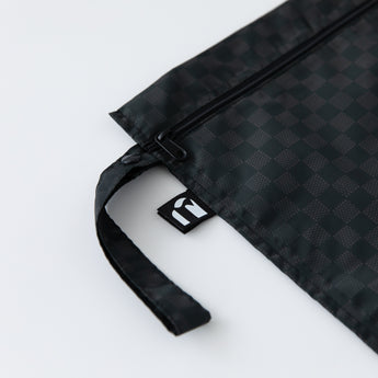 Close-up of Roamio by Bumkins Wet Bag: Rich Black on a white background, with focus on the side strap and logo tag.