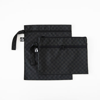 Two bags from Bumkins The Chaos Coordinator Deluxe 5-Piece Set: Rich Black lay overlapped on a white background.