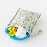 Bumkins Wet Bag: Cacti lays open on a white background with a white towel and colorful pool toys peeking out.