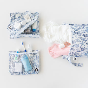 Roamio by Bumkins The Commuter Essential 4-Piece Set: Shells holds clothes and toiletries on a white background.