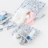 Roamio by Bumkins The Commuter Essential 4-Piece Set: Shells holds clothes and toiletries on a white background.