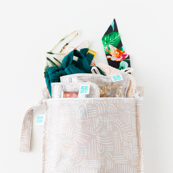Bumkins Wet Bag: Wander holds matching pouches and colorful swimwear on a white background.