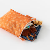Bumkins Wet Bag: Grounded lays open on a white background with clothes and swimwear peeking out.