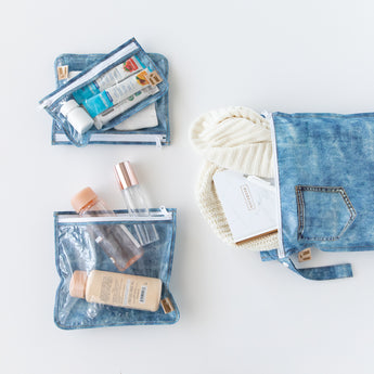 Roamio by Bumkins The Commuter Essential 4-Piece Set: Denim on Denim holds clothes and toiletries on a white background.