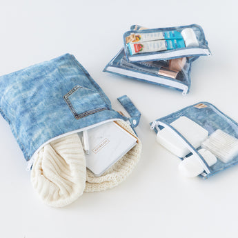 Roamio by Bumkins The Commuter Essential 4-Piece Set: Denim on Denim holds clothes and toiletries on a white background.