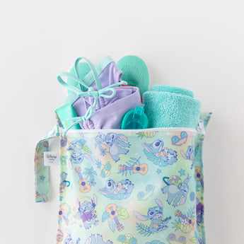 Bumkins Wet Bag + Wet/Dry Bag Set: Aloha Stitch, shown with towel, goggles, purple swimsuit & teal flip-flops on white.