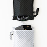Roamio by Bumkins Wet Bag 2 Pack: Rich & Boujee is neatly arranged on a white background with shoes, clothes, and a passport inside.