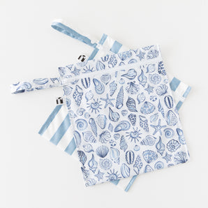 Two Roamio by Bumkins Wet Bag 2 Pack: Coastal, featuring blue seashells and stripes, overlap on a white background.
