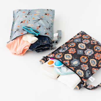 The Bumkins Wet Bag 2 Pack: Disney Everyday Is Halloween holds clothes, wipes, a toy & more on a white surface.