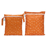 Bumkins Wet Bag + Wet/Dry Bag Set: Grounded—2 orange waterproof bags with white abstract arrow patterns and zipper closures.