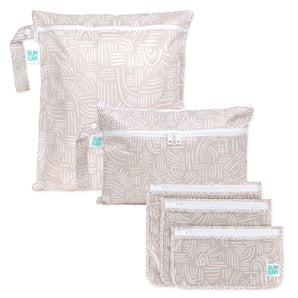 Bumkins Wander Set: Wet Bag, Wet/Dry Clutch & Clear Travel Bag—3 travel essentials in beige and white on a white background.