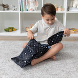 A boy sits on gray carpet with Bumkins The Chaos Coordinator Essential 4-Piece Set: Mickey Mouse Icon Black + White in a playroom.