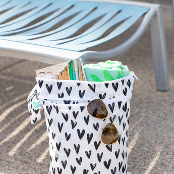 The Bumkins Wet Bag + Wet/Dry Bag Set: Hearts holds poolside essentials on a sunny day—perfect for summer packing.