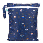 Bumkins Wet/Dry Bag: Evil Eye features celestial prints with eyes, stars, moons, and zodiac signs on dark blue waterproof fabric.