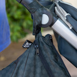 Close-up of a Bumkins Wet/Dry Bag: Rich Black, made from waterproof fabric, attached to a stroller handle.