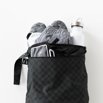 Roamio by Bumkins Wet/Dry Bag: Rich Black holds shoes, clothes, and a water bottle on a white background.