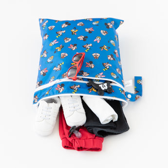 The Bumkins Wet/Dry Bag: Mickey & Friends Forever is shown open on a white background with red sunglasses, white sneakers, and clothes inside.
