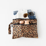 A bag from Roamio by Bumkins The Commuter Deluxe 5-Piece Set: Leopard holds sunglasses, clothes, and bottles on a white background.