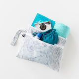 Roamio by Bumkins Wet/Dry Clutch: Disco Check holds a book, camera, towel, sunscreen, and swimsuit on a white background.