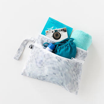 Roamio by Bumkins Wet/Dry Clutch: Disco Check holds a book, camera, towel, sunscreen, and swimsuit on a white background.