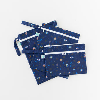 Bumkins Wet/Dry Clutch: Evil Eye is arranged on top of other similar bags in a fan shape on a white background.