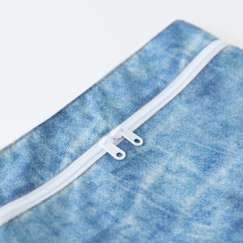 Close-up of Roamio by Bumkins Wet/Dry Clutch: Crushed Denim on a white background with focus on the dual zipper.