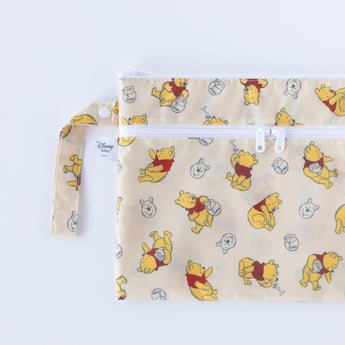 Bumkins Wet/Dry Clutch: Winnie Loves Hunny is half visible, displayed on a white background.