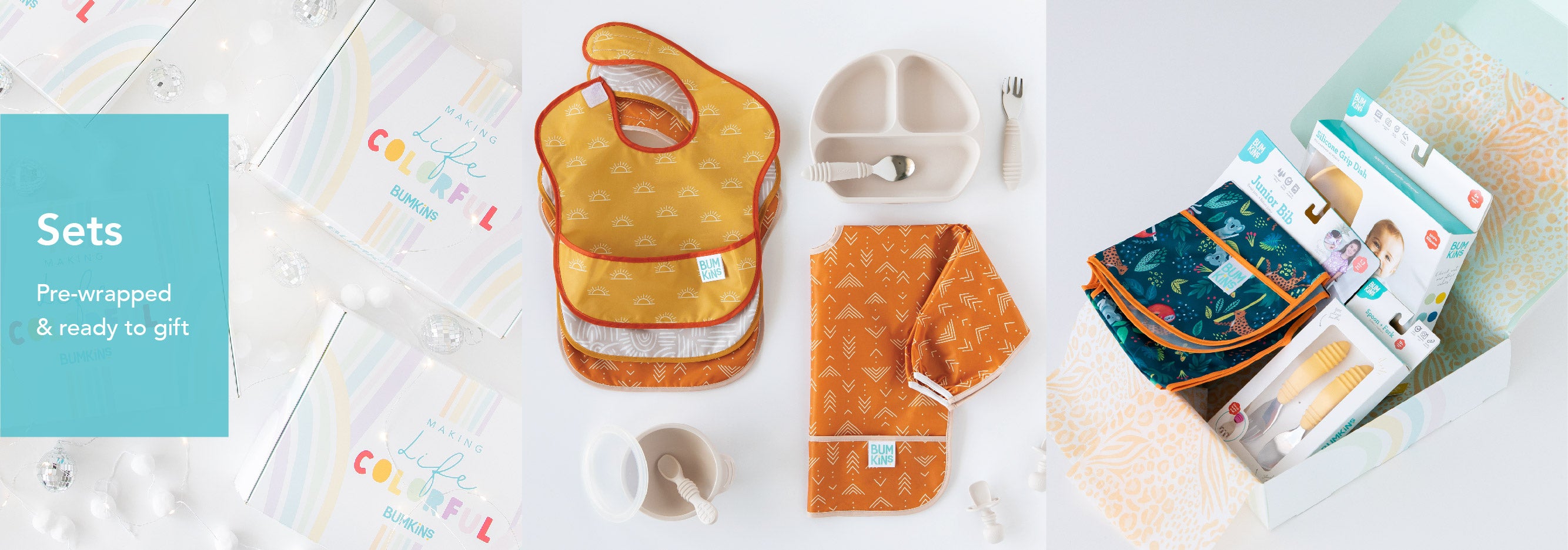 Gift sets of baby feeding and care items are displayed. The items include bibs in orange patterns, a silicone plate and cutlery, and packaged grooming tools. A label reads Sets: Pre-wrapped & ready to gift.