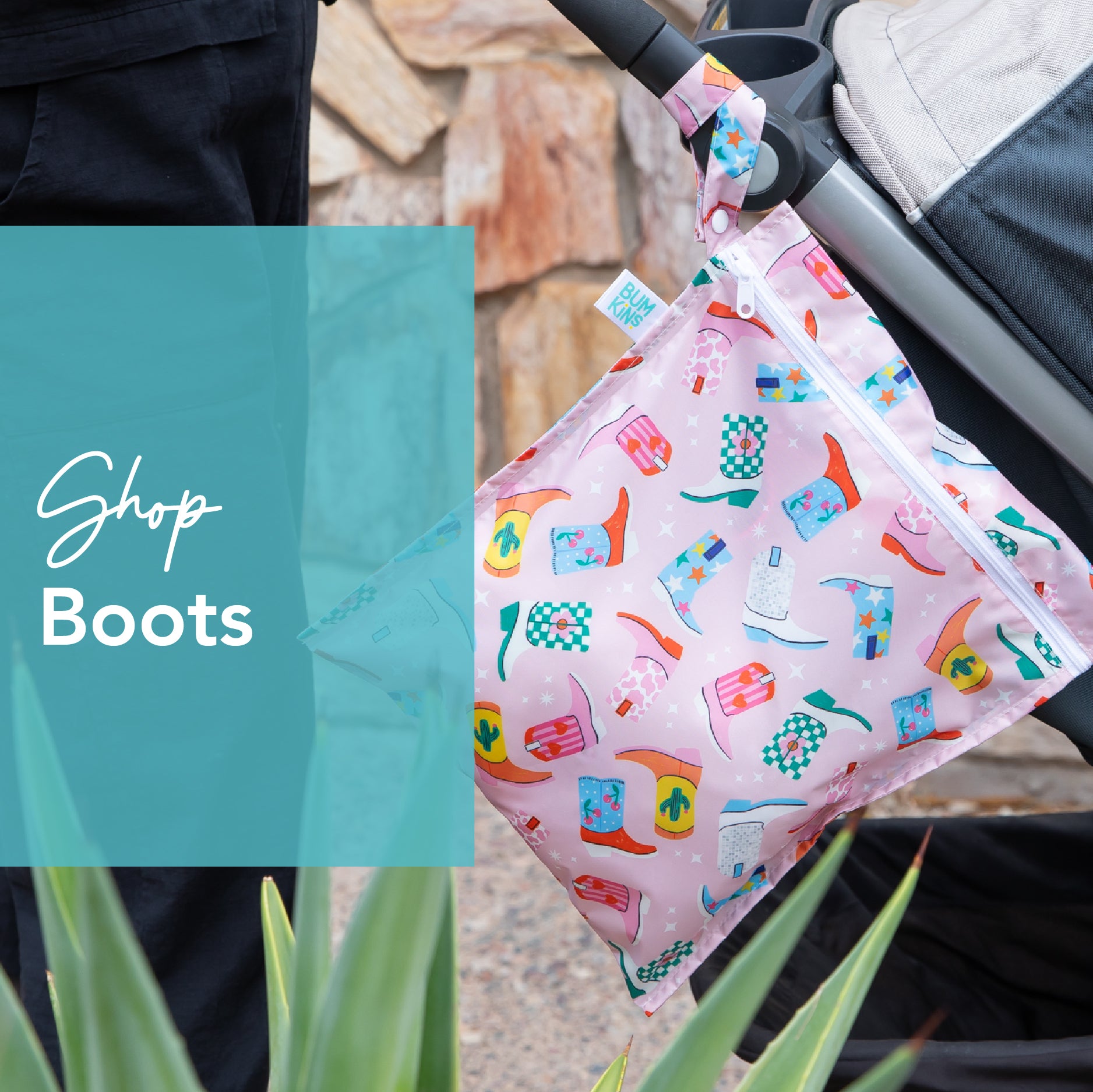 A person is pushing a stroller with a pink patterned bag attached. The bag features images of colorful boots and plants. There is a plant in the foreground. A blue transparent box displays the text Shop Boots.