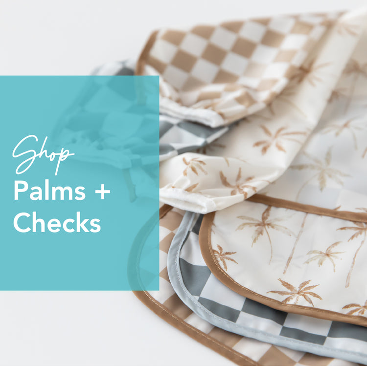 Close-up of folded fabrics featuring palm tree and checkered patterns in beige and gray tones. A blue transparent overlay on the left displays the text Shop Palms + Checks.