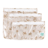 Bumkins Clear Travel Bag 3 Pack: Palm Daze includes three waterproof, TSA-compliant pouches with white zippers and a palm tree print.