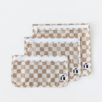 Roamio by Bumkins Clear Travel Bag 3 Pack: Sand Check lays neatly overlapped on a white background.