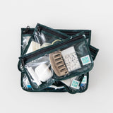Bumkins Clear Travel Bag 3 Pack: Starry Cactus are stacked on a white background, filled with toiletries, hair accessories and mints.