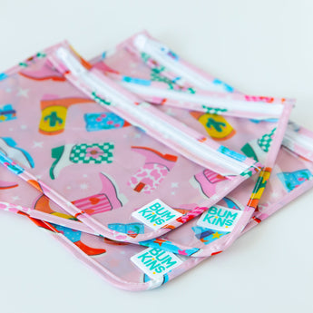 Close-up of Bumkins Clear Travel Bag 3 Pack: Boots stacked on a white background, showcasing the Bumkins logo label.