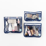 Bumkins Clear Travel Bag 3 Pack: Evil Eye, filled with makeup and toiletries, are set on a white background.