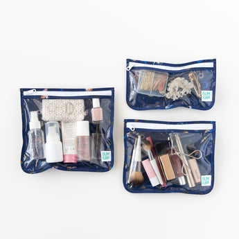 Bumkins Clear Travel Bag 3 Pack: Evil Eye, filled with makeup and toiletries, are set on a white background.